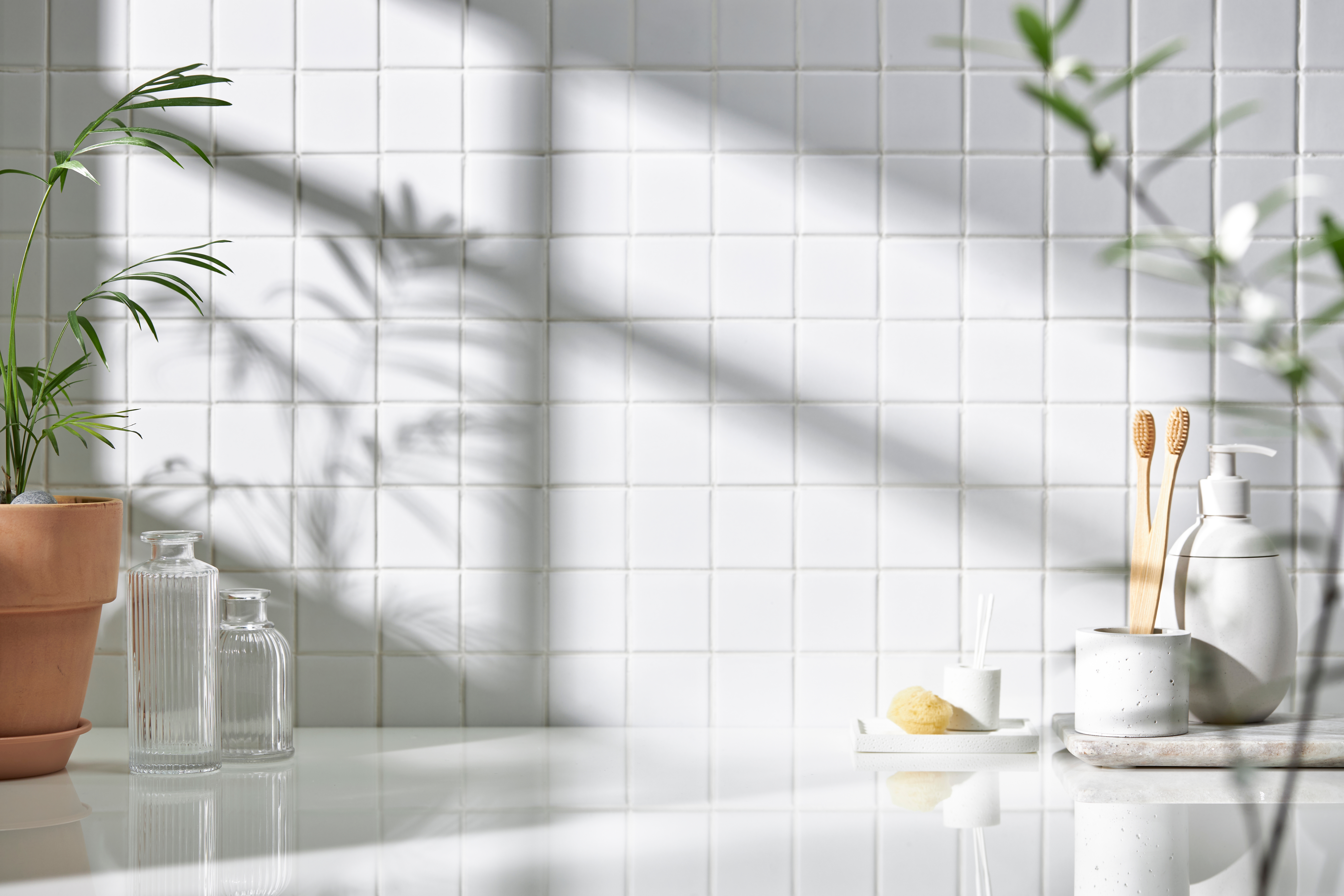 Various,Objects,On,A,White,Tile,Background,With,Warm,Sunlight